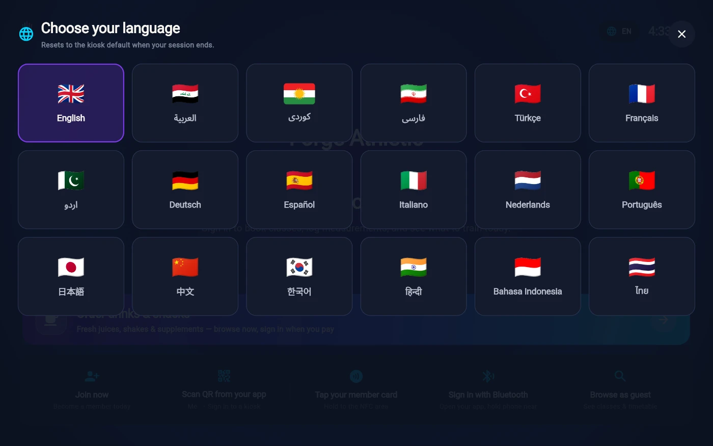The Choose your language sheet with the note Resets to the kiosk default when your session ends, and a grid of eighteen flag tiles - English selected, plus Arabic, Kurdish, Farsi, Turkish, French, Urdu, German, Spanish, Italian, Dutch, Portuguese, Japanese, Chinese, Korean, Hindi, Bahasa Indonesia and Thai.