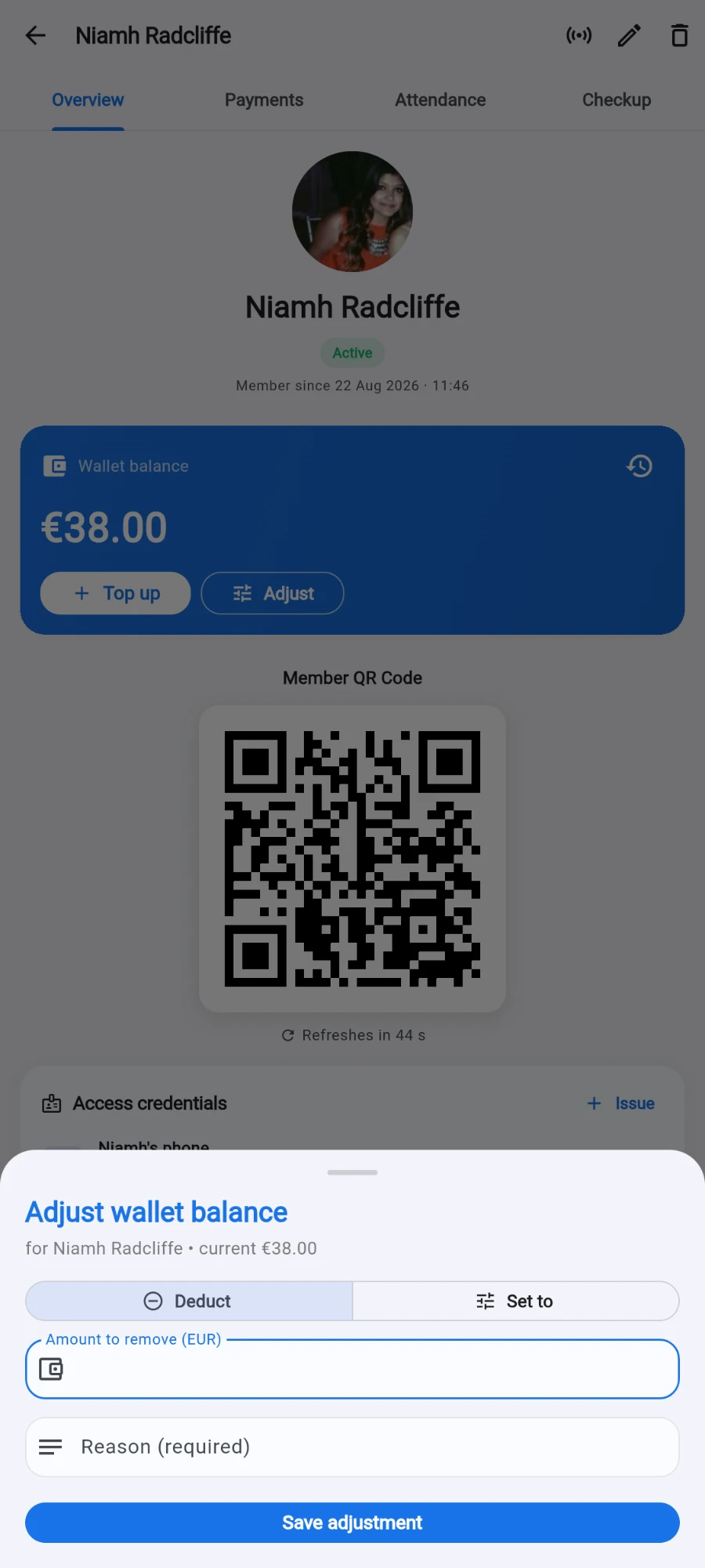The Adjust wallet balance sheet over a member's profile, reading 'for Niamh Radcliffe • current €38.00', with Deduct selected next to Set to, an 'Amount to remove (EUR)' field, an empty 'Reason (required)' field and the Save adjustment button — the blue Wallet balance card with Top up and Adjust visible behind it