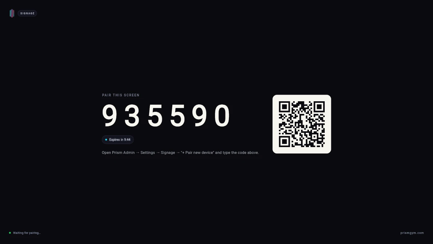 The signage player's pairing screen on the TV: a SIGNAGE badge top-left, PAIR THIS SCREEN above the 6-digit code 935590, an “Expires in 9:44” chip, a QR code on the right, the line “Open Prism Admin → Settings → Signage → '+ Pair new device' and type the code above”, and “Waiting for pairing…” along the bottom