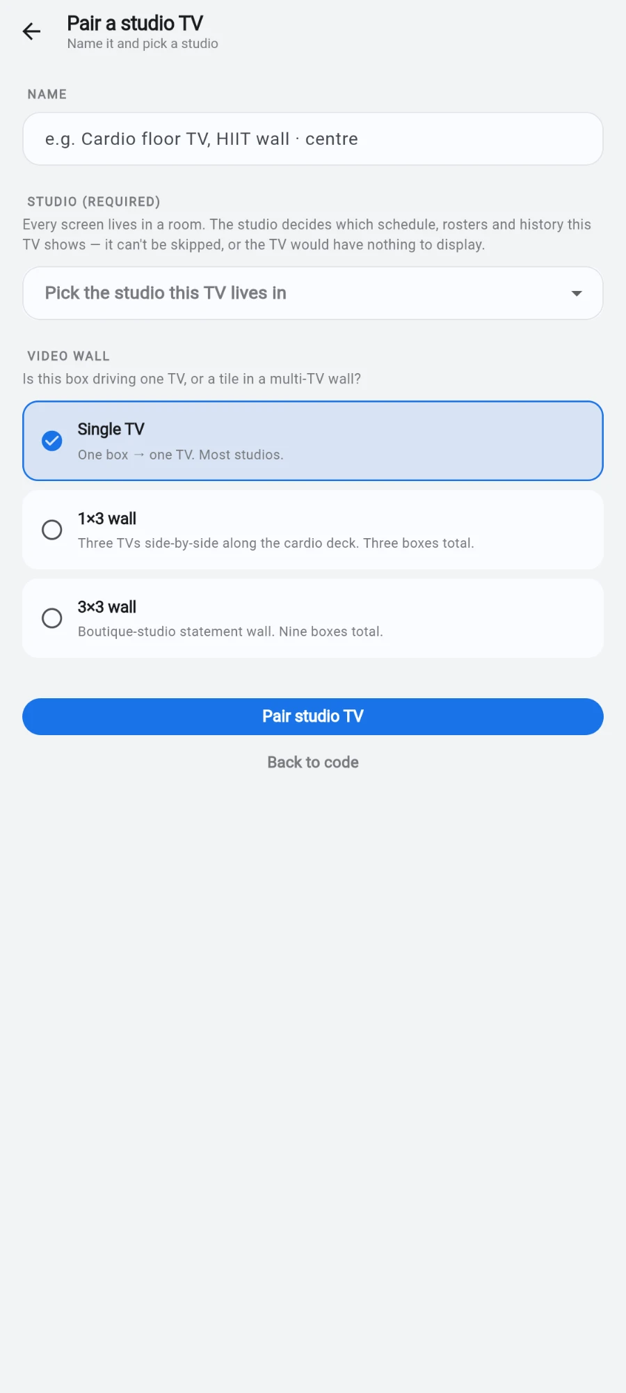The Pair a studio TV configuration step: a NAME field hinting “e.g. Cardio floor TV, HIIT wall · centre”, STUDIO (REQUIRED) with the picker “Pick the studio this TV lives in”, and the VIDEO WALL choices Single TV, 1×3 wall and 3×3 wall above the Pair studio TV button